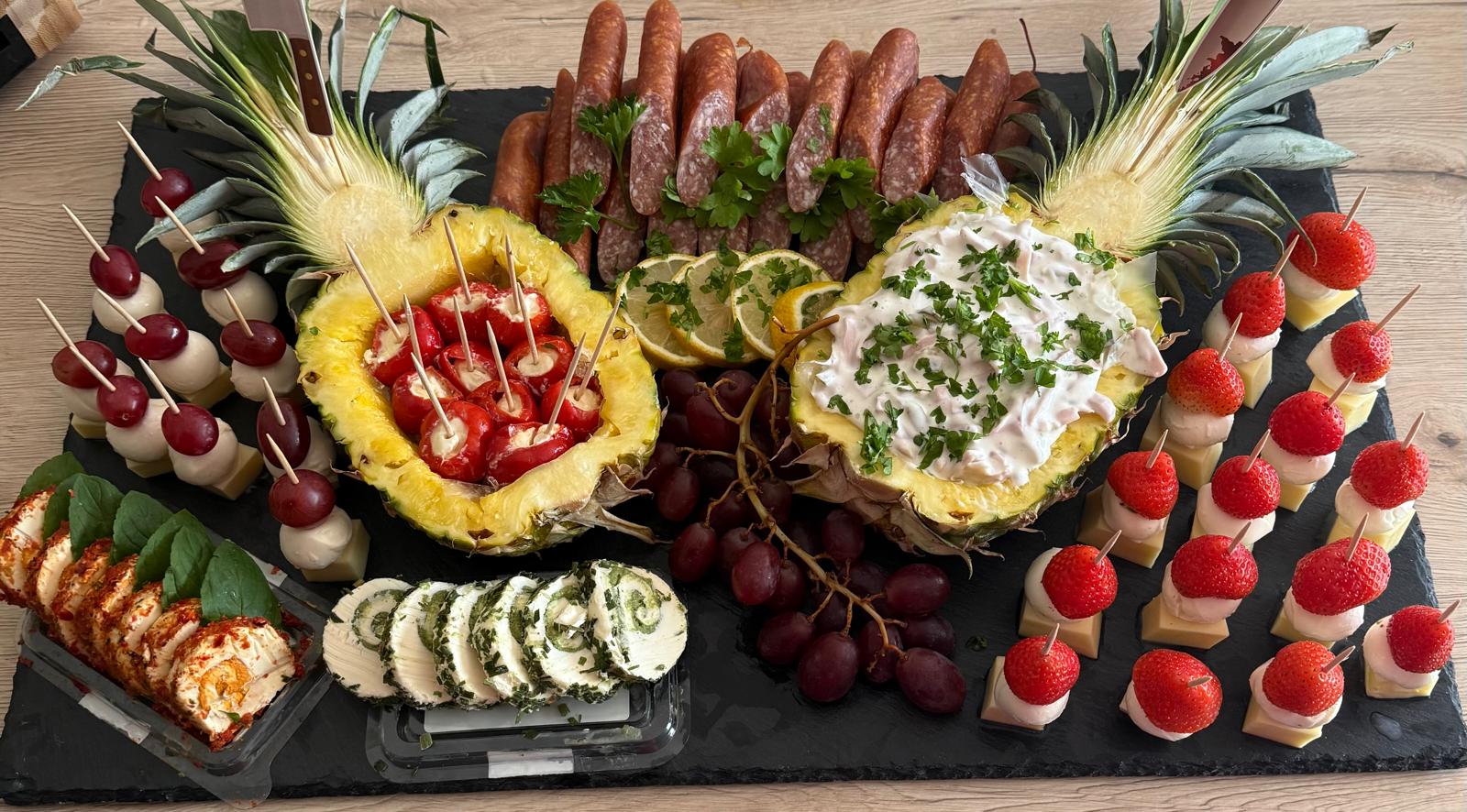 Buffetplatte mit belegten Häppchen, Obst und dekorativ angerichteten Salaten Buffetplatte mit belegten Häppchen, Obst und dekorativ angerichteten Salaten